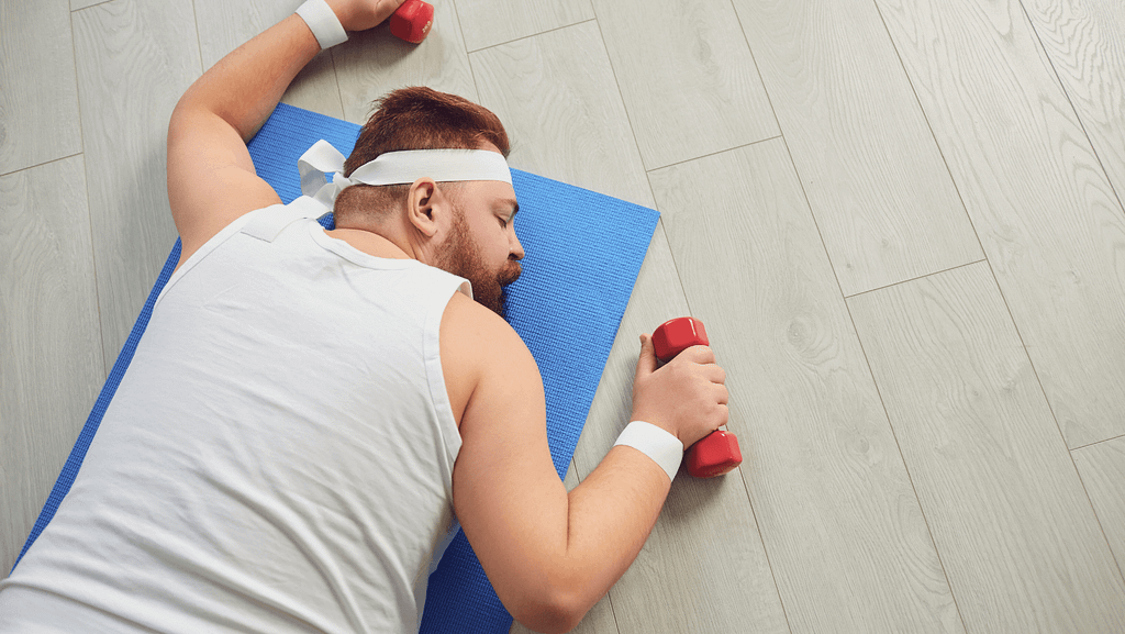man on the floor with dumbbells