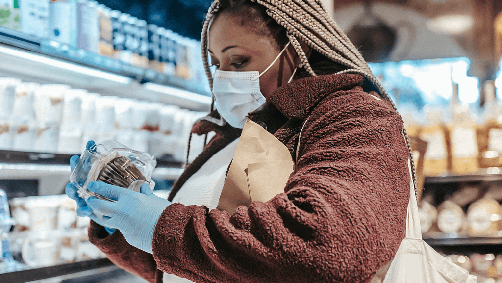 African woman reading food label in a supermarket